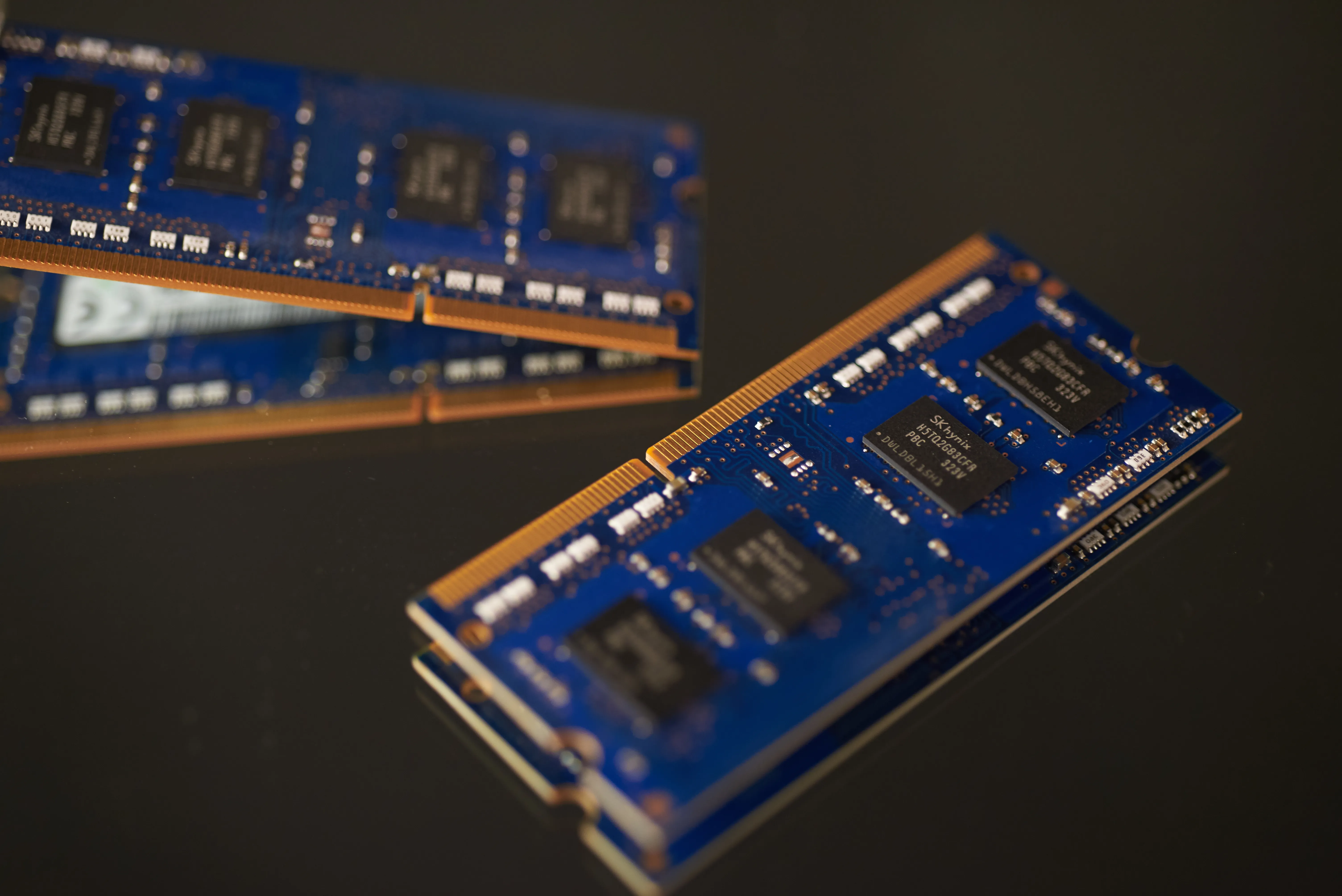 A 16:9 professional close-up shot of DDR4 and DDR5 RAM modules installed on a motherboard with dramatic lighting.